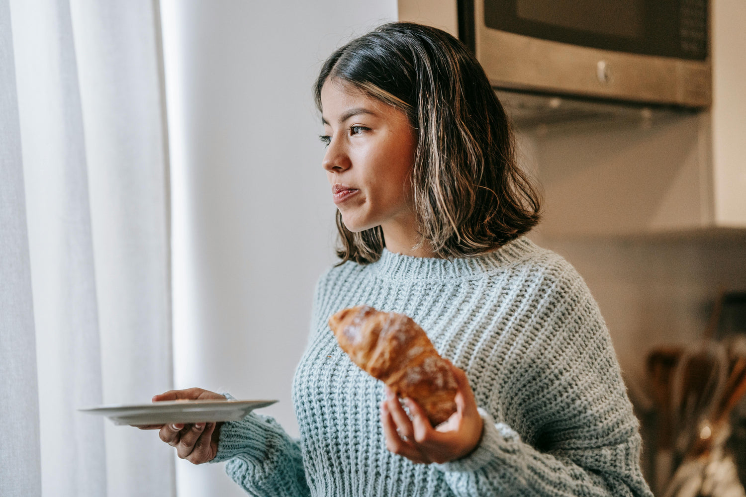 Bild på kvinna som äter croissant 