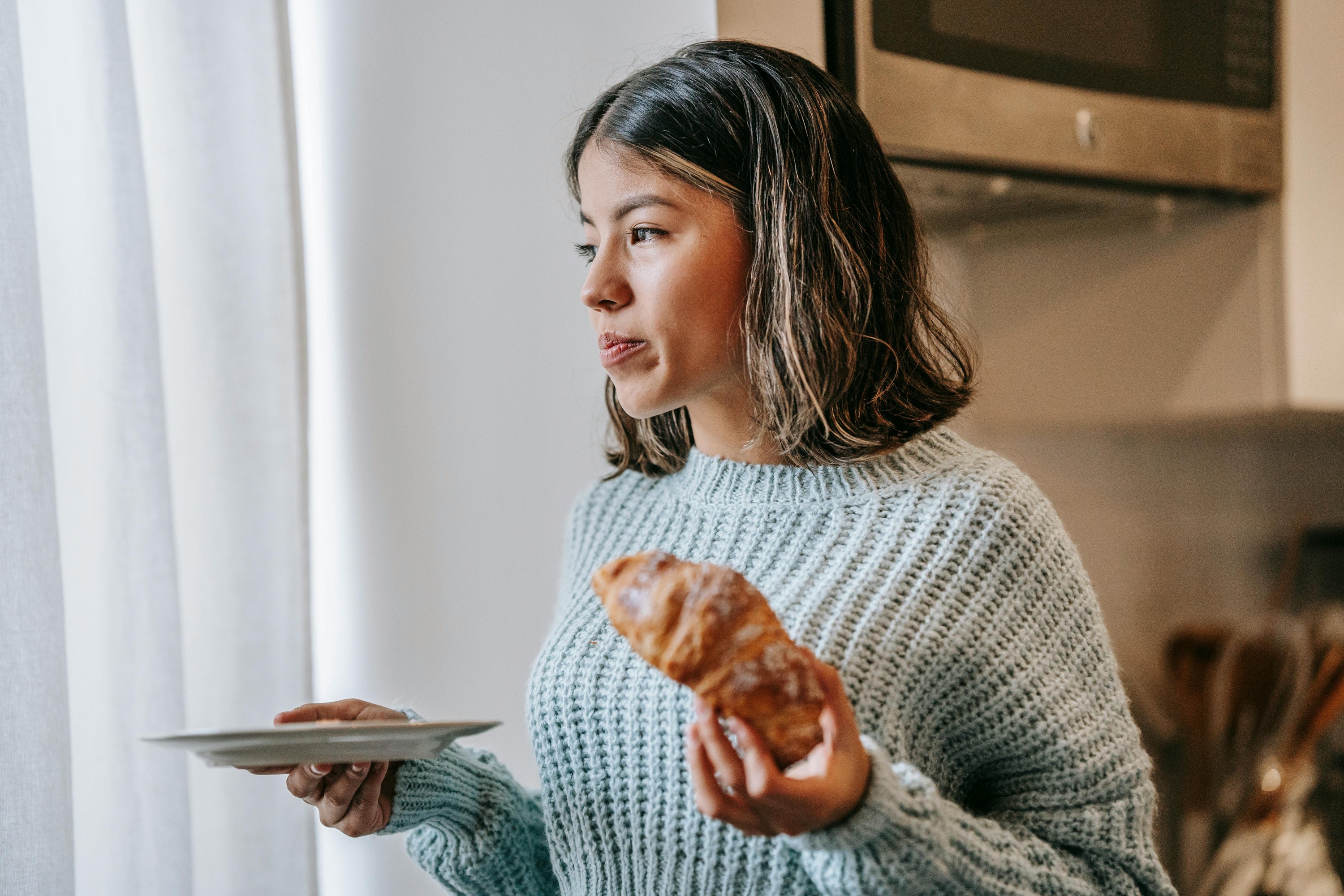 Bild på kvinna som äter croissant 